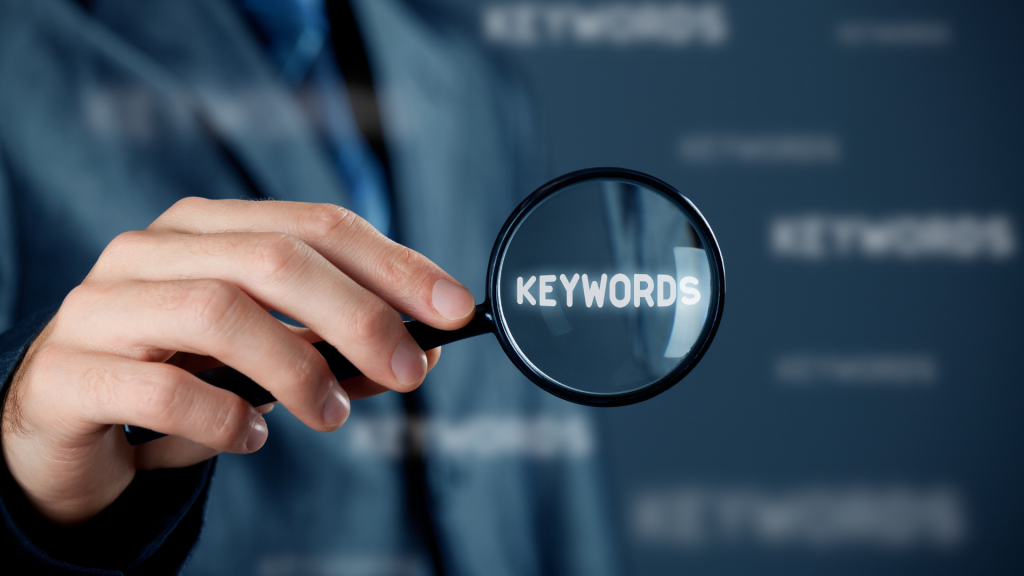 a person holding a magnifying glass over the word 'keywords'