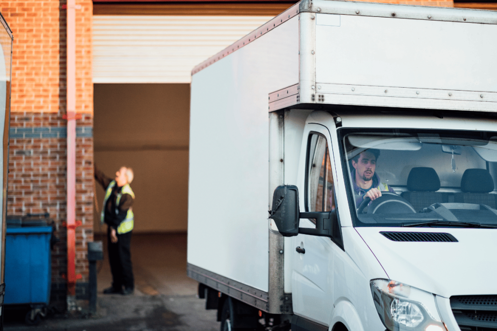 a white luton van reversing into a loading bay