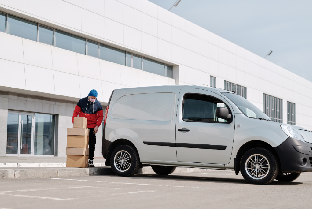 a courier unloading parcels from a small van 