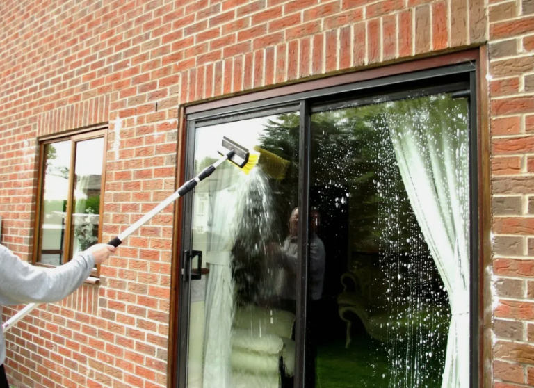 a person cleaning a patio door window