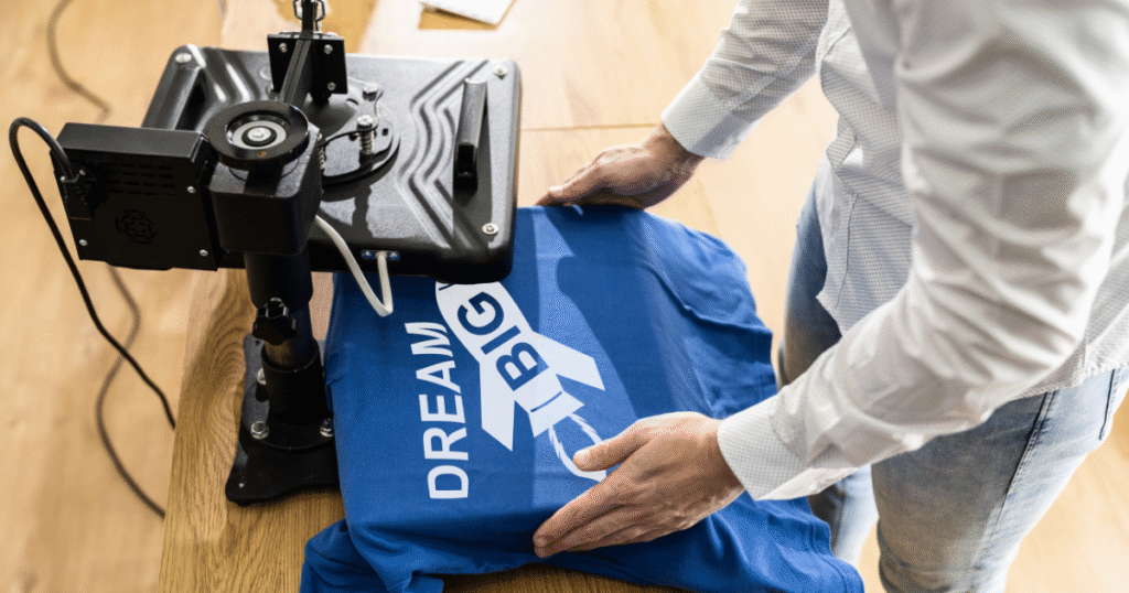 a man printing the words dream big on a blue t-shirt